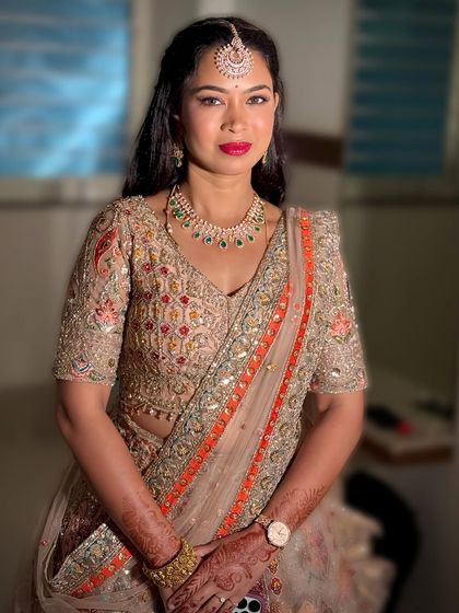 Padmashree looking regal in a heavily embroidered lehenga for her brother's reception. The makeup is glamorous with a bold red lip.