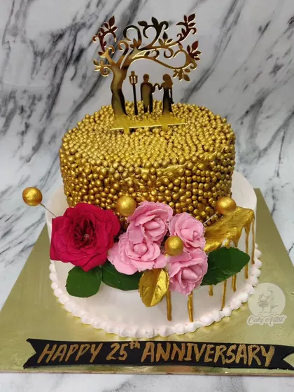 A grand celebration for a 25th anniversary! This two-tier cake features a top tier covered in gold sprinkles, a golden couple topper, and beautiful fresh roses.