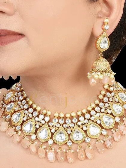 A lovely antique gold Kundan choker with soft pink beads. This set, which includes teardrop-shaped Kundan work and matching jhumkas, is perfect for a romantic, pastel-themed wedding.