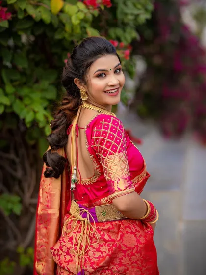 The back view of the South Indian bridal look, showing off the beautiful blouse design and hairstyle.
