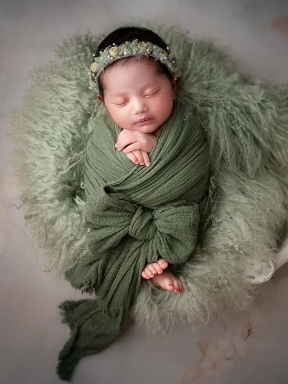 The most adorable newborns in the classiest of setups. A simple green swaddle and a soft, furry base are all that's needed to create a stunning, baby-focused portrait.