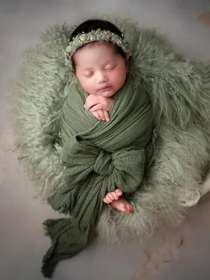 The most adorable newborns in the classiest of setups. A simple green swaddle and a soft, furry base are all that's needed to create a stunning, baby-focused portrait.