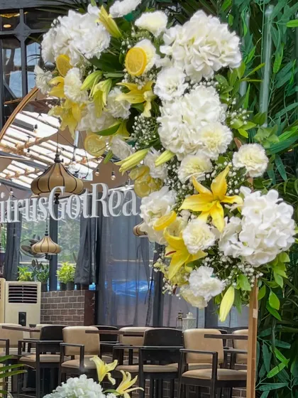 Details make the design. For a 'Citrus Got Real' baby shower, I created this elegant photo spot using a custom-monogrammed mirror adorned with fresh hydrangeas, lilies, and lemon slices for a zesty, refreshing touch.