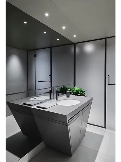 The gym's bathroom continues the modern aesthetic with a custom-designed vanity, sleek fixtures, and a monochrome color scheme.