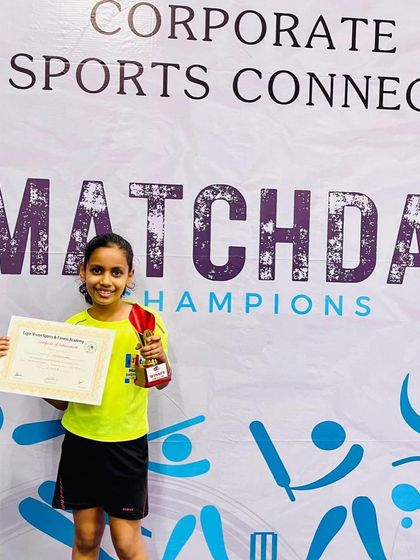 Kashvi celebrating her win in the Under-9 category at the Corporate Sports Connect open tournament. Her smile and trophy are a testament to her passion for the game.