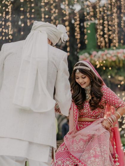A happy bride with her hair styled in soft, flowing curls for her wedding ceremony. It's a romantic and beautiful choice for a modern bride.