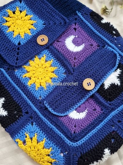 Close-up on the front pocket and flap of the galaxy backpack, highlighting the intricate sun, moon, and star patterns.