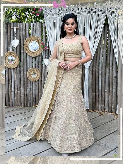 A full-length shot of the beige lehenga against a rustic backdrop, showing its timeless elegance.