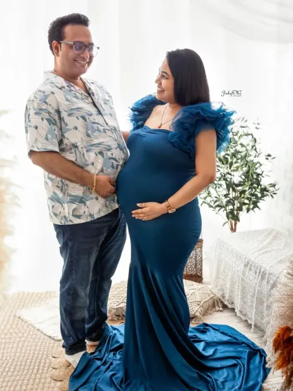 A classic standing pose for a maternity portrait. The rich blue gown looks stunning in my bright studio, and the couple's happy expressions say it all.