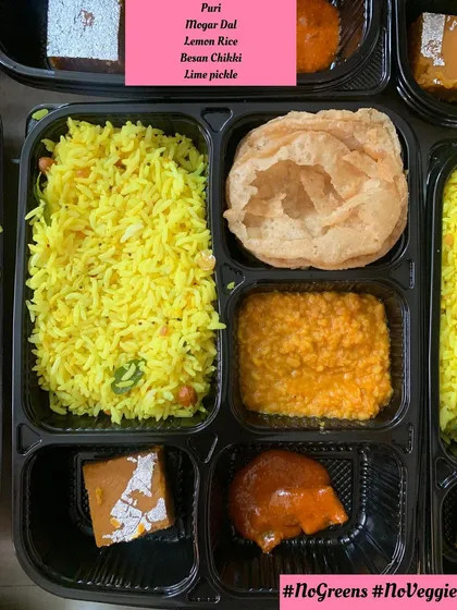 I take special care for religious observances like Paryushan. This is a pure Jain meal thali prepared without any green vegetables, onions, or garlic, featuring dishes like lemon rice, mogar dal, and besan chikki.