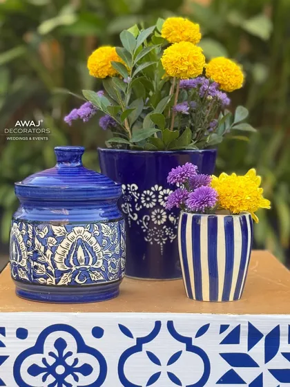 A collection of hand-painted ceramic jars used for the floral decor, adding an authentic and artisanal touch to the Haldi theme.