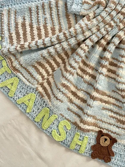 This close up shows the texture of the knitted blanket and the detail of the personalization. This premium blanket makes a very special gift that you can't find in stores.