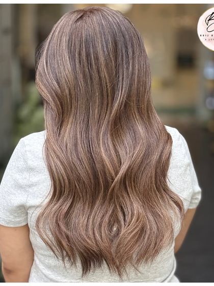 The back view of this ash blonde balayage shows the beautiful, cool-toned highlights and healthy waves.