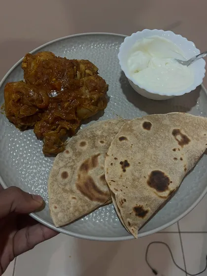 A simple and effective meal: chicken with two rotis and a side of curd. This is a great way to get in protein and carbs after a workout.