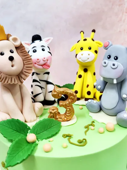 A detailed close-up of the handcrafted jungle animal toppers, showcasing their playful expressions and unique features.