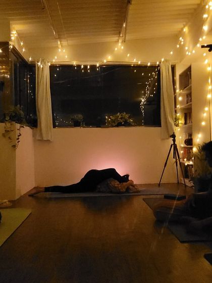A quiet moment of deep stretching in our candlelit studio. This pose helps to release the lower back and open the hips.