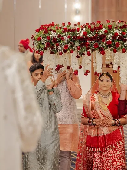 The groom's view as his bride walks towards him under a lush 'phoolon ki chadar' of red roses and jasmine. We choreograph these entries to create maximum emotional impact.