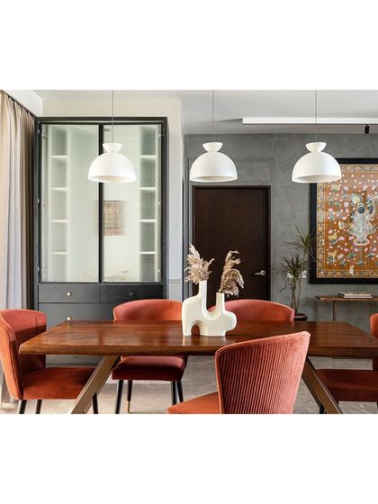 This view showcases the custom Pichwai painting, a nod to the clients' admiration for Indian art. The artwork, combined with the rustic live-edge table and modern pendant lights, creates a dining space that is both luxurious and grounded.