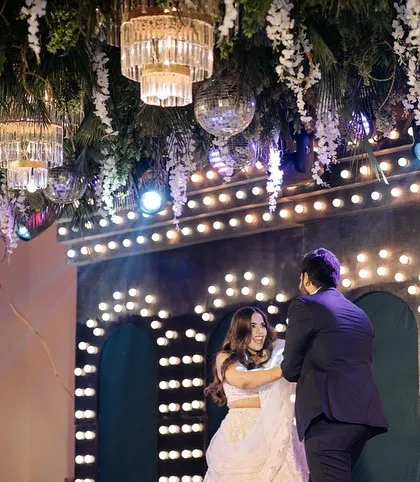 The couple on stage during their performance, framed by a ceiling of hanging foliage, chandeliers, and disco balls. This 'Retro Jungle' theme was all about combining classic glamour with a touch of the wild.