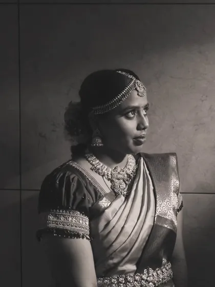 A black and white photo that captures the timeless elegance of Priya's muhurtham look. The focus is on her expression and the beautiful jewelry.