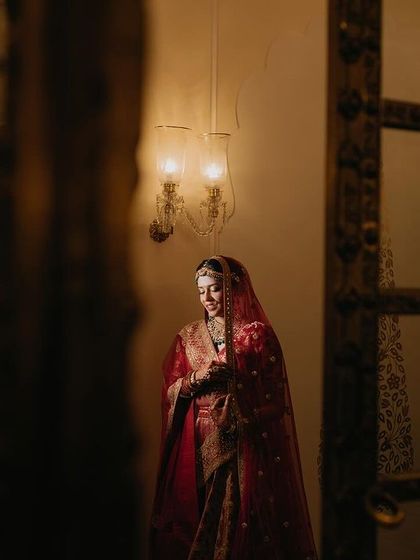 A candid shot of Tanya, full of grace and happiness. The image captures her in a moment of quiet joy, framed by the elegant architecture of the venue.