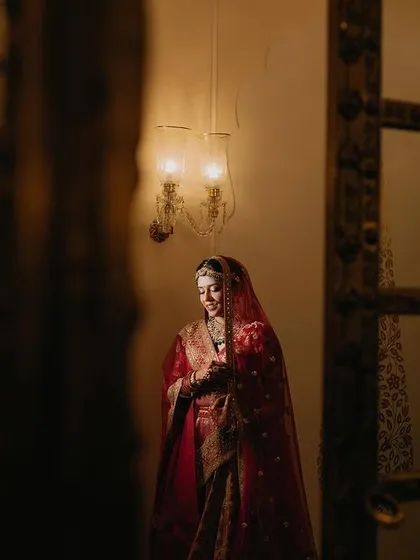 A candid shot of Tanya, full of grace and happiness. The image captures her in a moment of quiet joy, framed by the elegant architecture of the venue.
