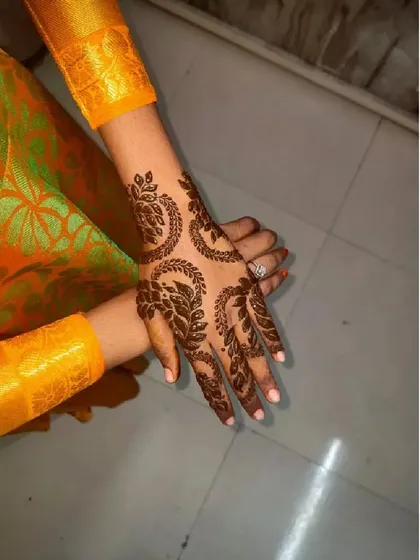 This design features repeating leafy crescents that create a beautiful, flowing pattern across the back of the hand.