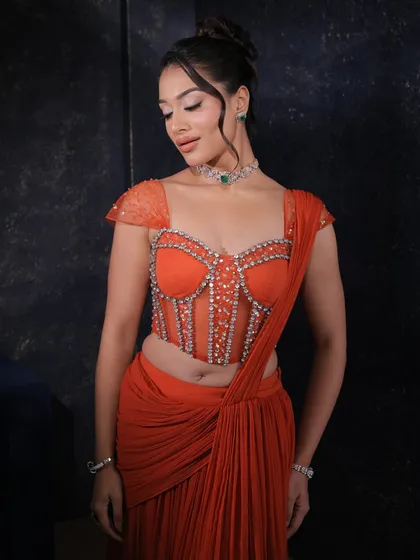 A close-up of the orange concept saree's corset blouse, showcasing the intricate stonework and the delicate cap sleeves.