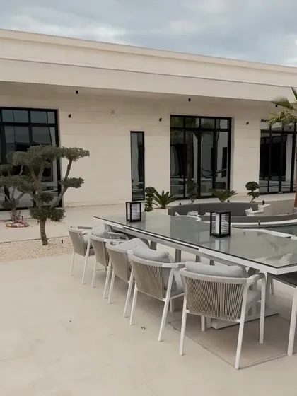 An outdoor dining area set against the backdrop of our minimalist poolside planting. The carefully chosen trees add a touch of green that complements the modern furniture and architecture.