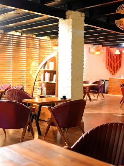 The indoor area of Sasa Cafe combines rustic wooden elements with modern, comfortable seating. It's a warm and inviting space, whether you're here for a coffee, a meal, or just to unwind with a good book.
