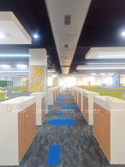 This image shows a large-scale office fit-out, demonstrating our capacity to handle extensive floor plates. The layout features rows of workstations with integrated low-height storage cabinets, designed for efficiency and easy movement. The patterned carpet tiles add visual interest and help with acoustic management in the open space.
