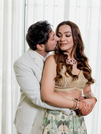 An intimate embrace during a Roka ceremony. The couple's modern outfits and the soft lighting create a chic and romantic mood.