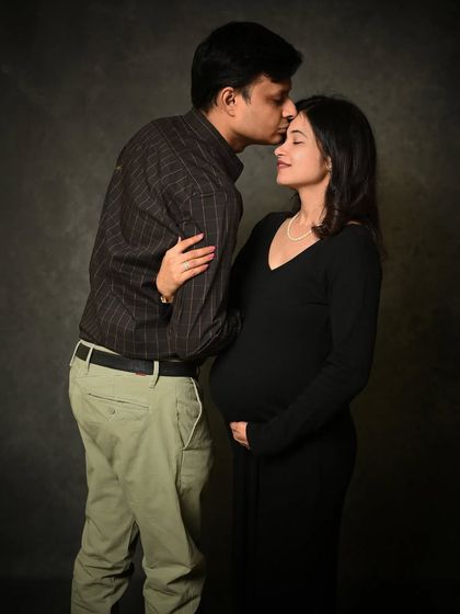 A classic and elegant maternity portrait against a textured, dark background. This style creates a timeless, painting-like quality that looks stunning as a framed print.