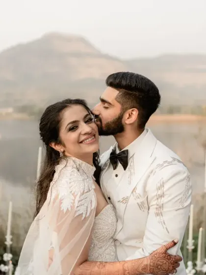 A gentle kiss against a backdrop of mountains and water. This is a fairytale moment, soft and tender, capturing the quiet promise of a lifetime together. It’s the elegance and emotion of a white wedding ceremony.
