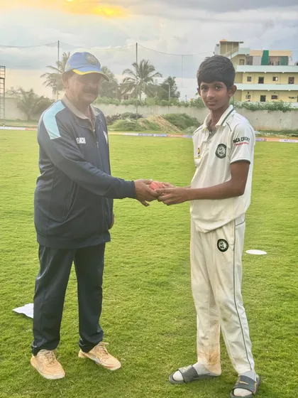 A coach presents the match ball to a U-19 player for his outstanding performance.