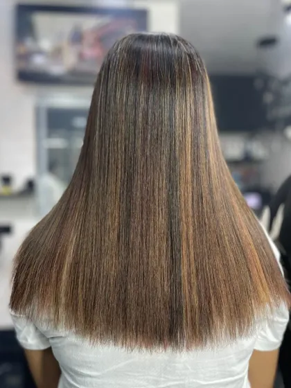 This is the result of a professional straightening treatment. The hair is perfectly uniform from root to tip, with a healthy shine that indicates it was done with care to protect the hair's integrity.