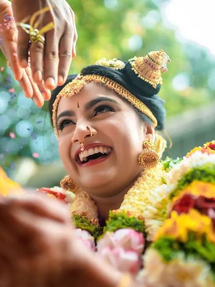 A close up of a bride's joyful face as she participates in a wedding ritual. We focus on capturing genuine, happy expressions.
