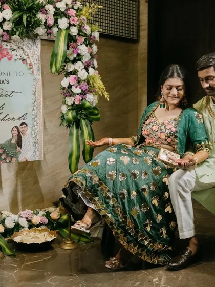 I love seeing my clients enjoy the space we create together. Here, the couple is seated in front of a custom welcome sign designed just for their Geet and Mehendi function. The lush floral arch framing the sign adds a touch of elegance and makes for a beautiful entrance and photo opportunity.