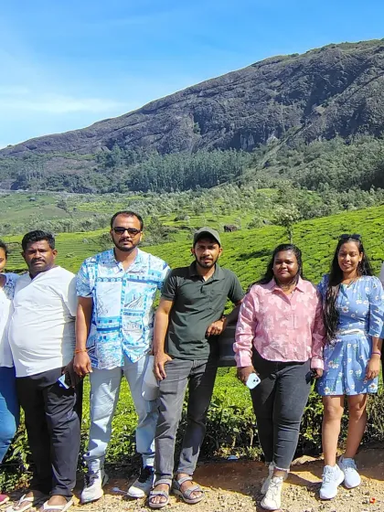 A group photo amidst the tea plantations in Munnar. The vibrant green of the tea leaves against the backdrop of the mountains is a sight to behold.
