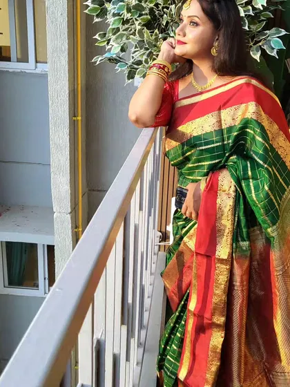A lovely outdoor shot showcasing the rich colors of the silk saree. The open pallu style looks particularly stunning in natural light.
