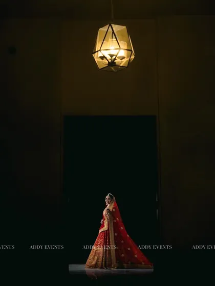 A cinematic and artistic bridal portrait, with the bride standing alone under a single spotlight, creating a dramatic and powerful image.