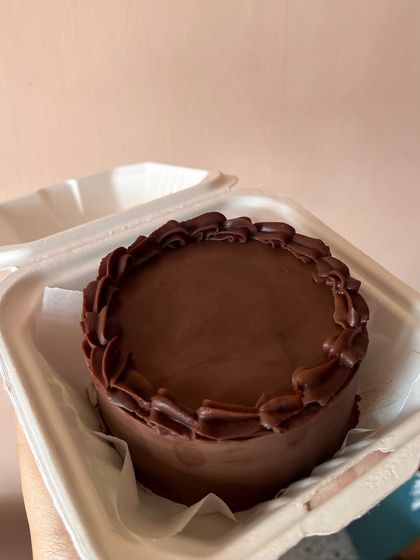 A simple yet decadent chocolate bento cake. It's a rich chocolate sponge covered in smooth dark chocolate ganache with a piped border.