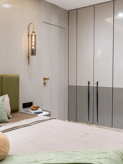 This dreamy daughter’s bedroom pairs muted grey wardrobes with a chic wall bracket light that sets the perfect ambient mood. The PU-finish louvred shutters add a refined texture, blending modern style with timeless comfort.