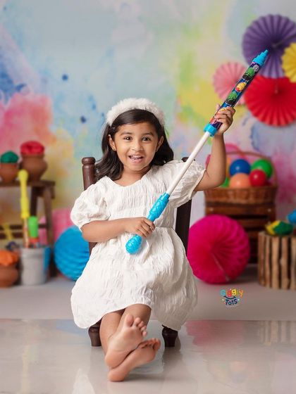 Ready for the festival of colors! A little girl holds a pichkari, excited to celebrate Holi in our vibrant studio.