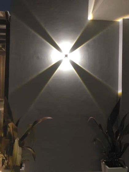 A close-up of a four-way wall light, which creates a dramatic starburst effect and serves as a decorative feature in itself.