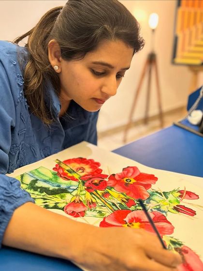 A student carefully renders the petals of a vibrant red poppy in watercolor. This medium is perfect for capturing delicate details and luminous color.