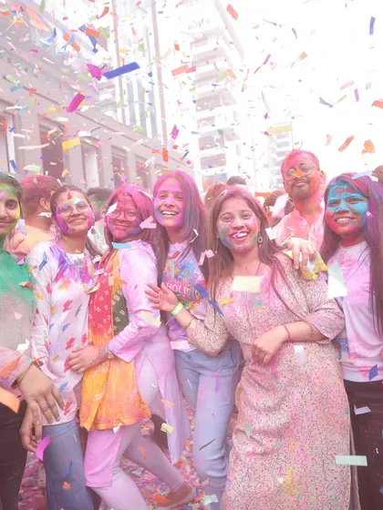 A moment of shared joy at a corporate Holi party. This photo captures employees smiling and covered in colors under a shower of confetti, reflecting the fun and engaging atmosphere we create.