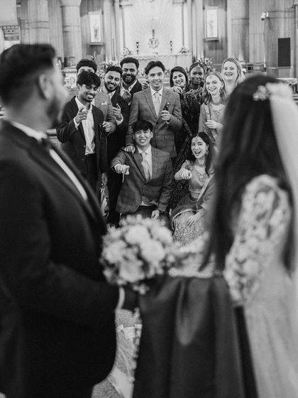 A fun, candid shot of the wedding party inside the church, showing the joy and support of friends and family.