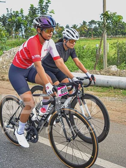 Two female cyclists ride shoulder-to-shoulder, showcasing the strength and skill in our women's category. I am dedicated to promoting women's competitive cycling.