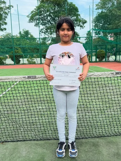 Ziya standing proudly on the court with her Certificate of Merit from the DLTA Open Mini Tennis Tournament. Every tournament is a valuable learning experience.